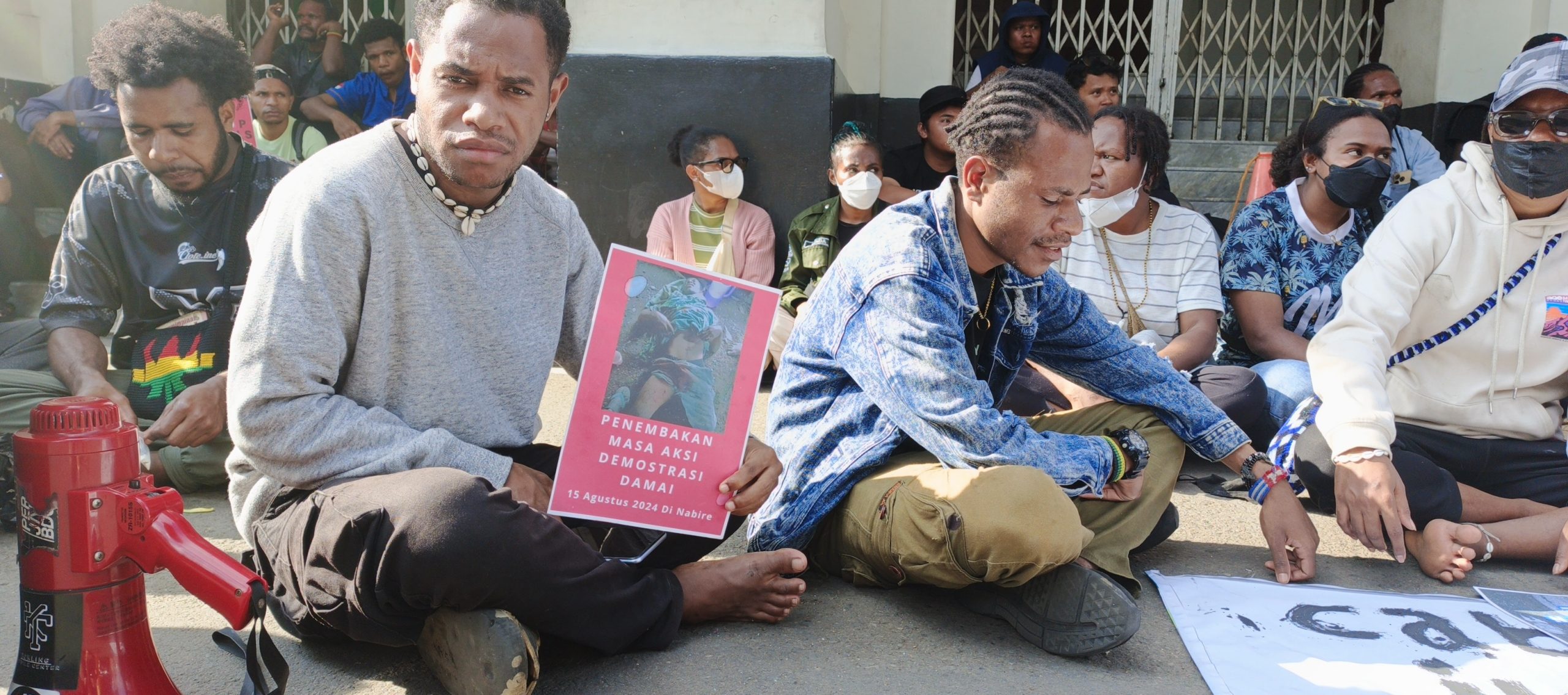 Aksi Tolak 58 Tahun Freeport Ilegal di West Papua dan RUU TNI di Gedung Merdeka 2 Peserta Aksi Menunjukan Poster foto kekerasan oleh Militer di depan gedung Merdeka Bandung