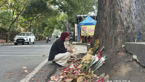 Salah seorang warga tengah ikut menabur bunga serta mendoakan almarhum Muhammad Fahdly Arjasubrata di lokasi kejadian perkara kasus pengeroyokan di Jalan Cihampelas, Kota Bandung, Jawa Barat, Mingu (15/3/2026). ANTARA/Rubby Jovan/pri.
