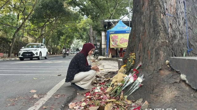 Salah seorang warga tengah ikut menabur bunga serta mendoakan almarhum Muhammad Fahdly Arjasubrata di lokasi kejadian perkara kasus pengeroyokan di Jalan Cihampelas, Kota Bandung, Jawa Barat, Mingu (15/3/2026). ANTARA/Rubby Jovan/pri.