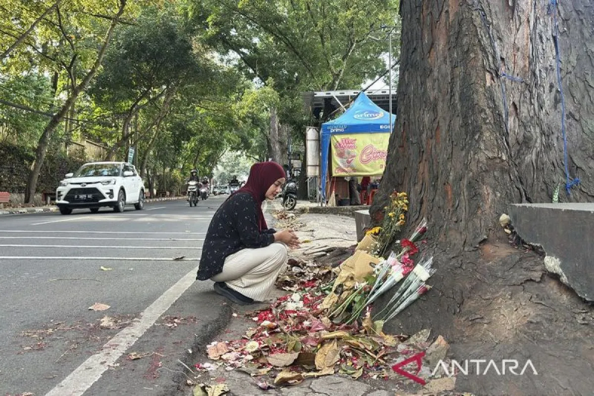 Salah seorang warga tengah ikut menabur bunga serta mendoakan almarhum Muhammad Fahdly Arjasubrata di lokasi kejadian perkara kasus pengeroyokan di Jalan Cihampelas, Kota Bandung, Jawa Barat, Mingu (15/3/2026). ANTARA/Rubby Jovan/pri.