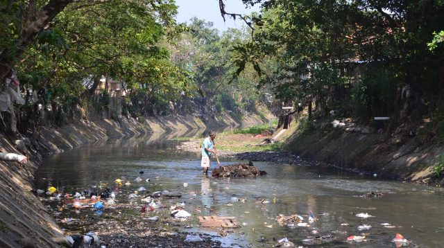 Seorang warga sedang membersihkan sampah di Sungai Bojongsoang, Kab. Bandung, Senin (13/07/2026). Foto: Juni, Pers Mahasiswa sEntra